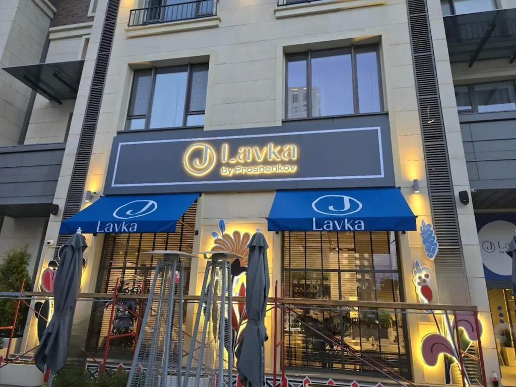 Custom outdoor lightbox sign and branded awnings for Lavka restaurant storefront